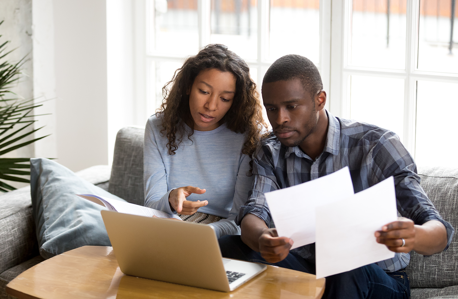 Two Christian investors sitting at a table together, looking for faith-based investing options.